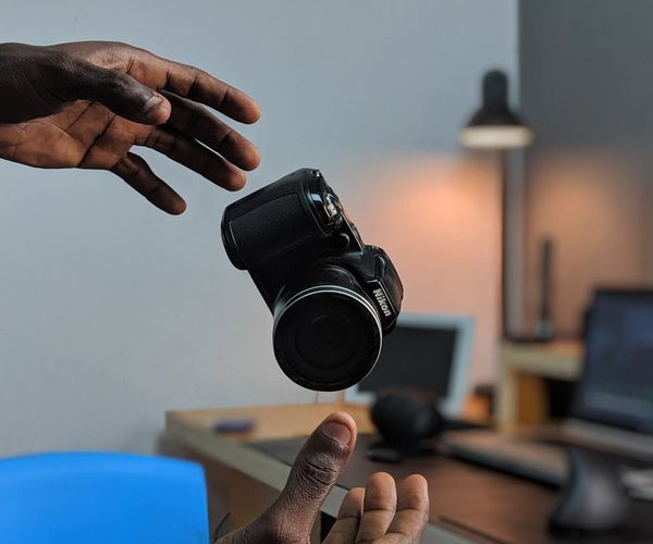 A person in motion, captured mid-stretch in a spacious, sunlit studio.